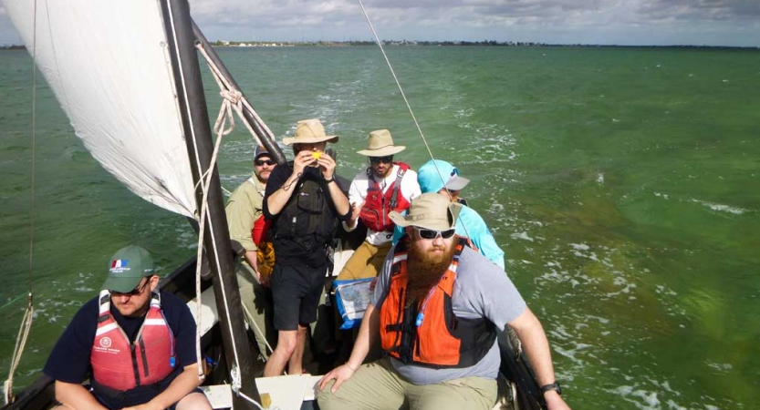 a group of veterans navigate open waters on an outward bound sailing trip